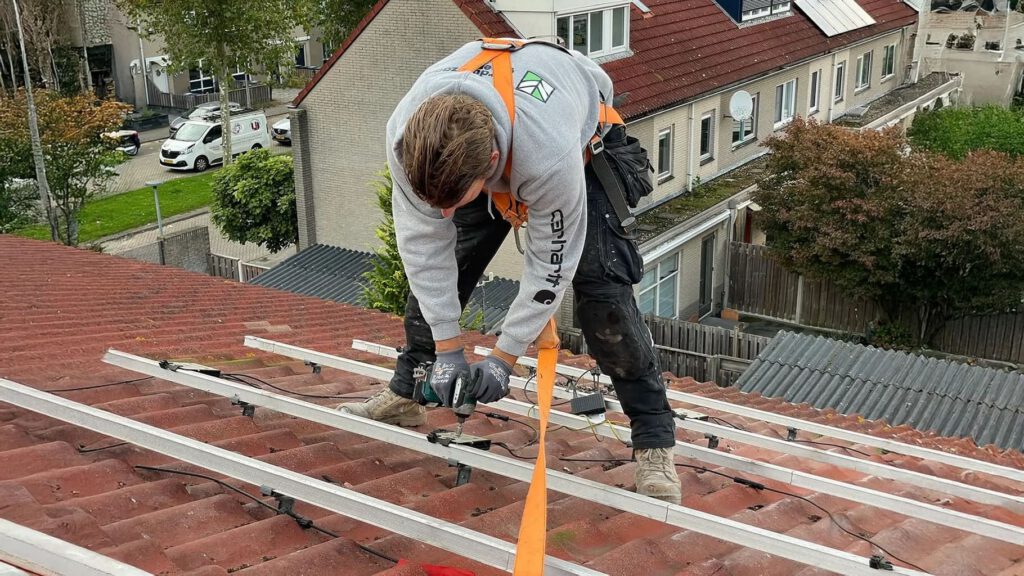 Monteur verwijdert zonnepanelen voor werkzaamheden aan het dak
