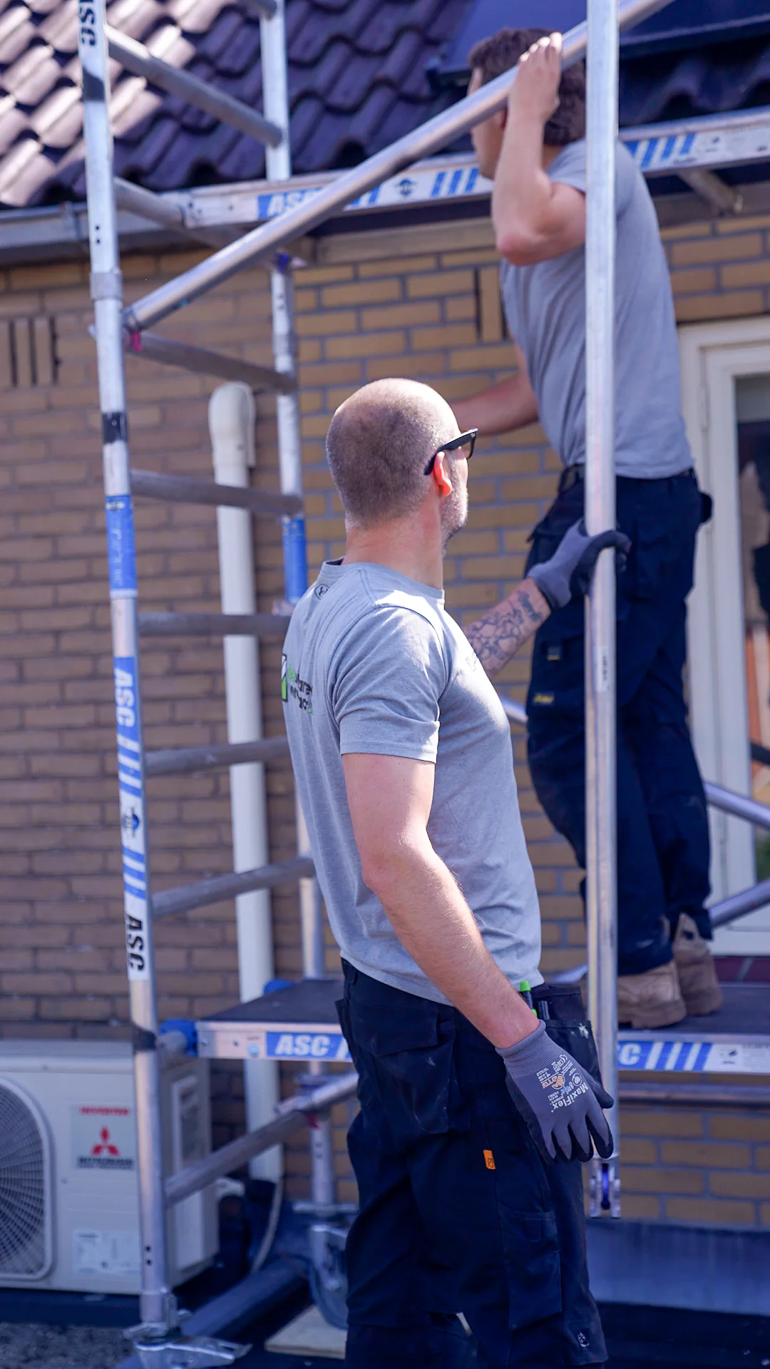Monteurs werken aan de steiger bij een woning